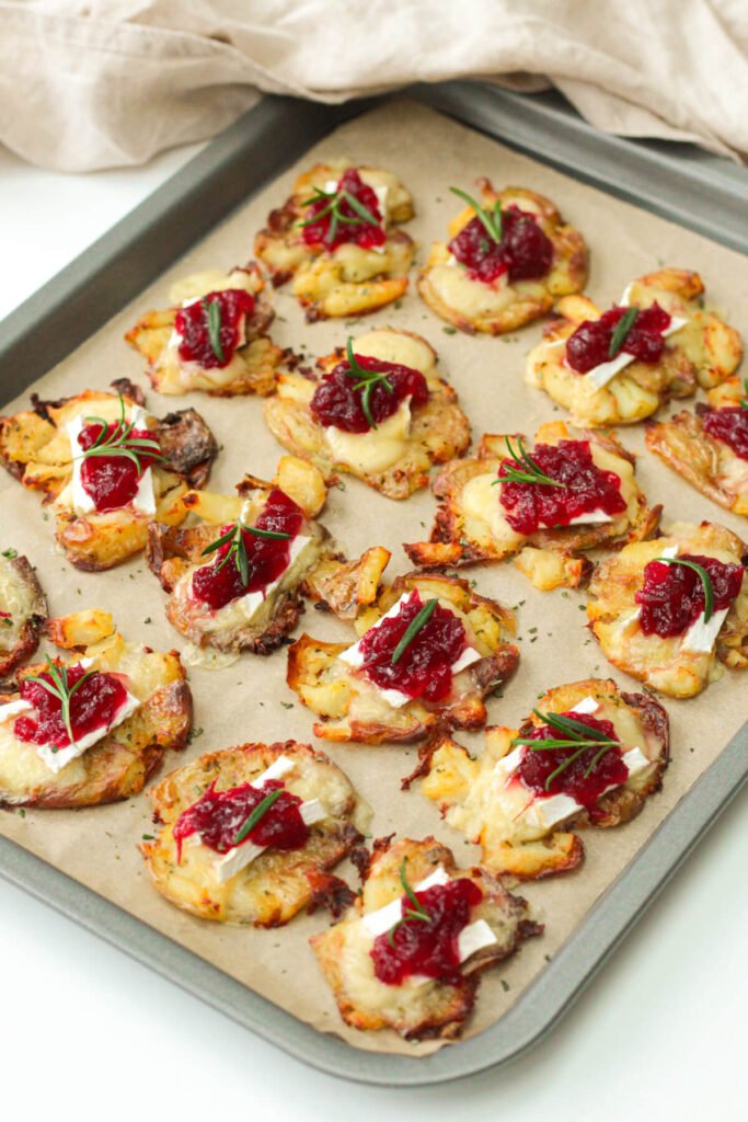 brie and cranberry smashed potatoes on a baking tray