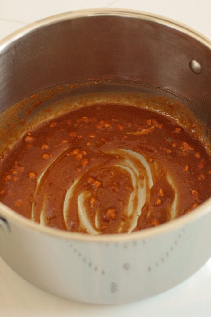 Thick brown sauce in a pot.