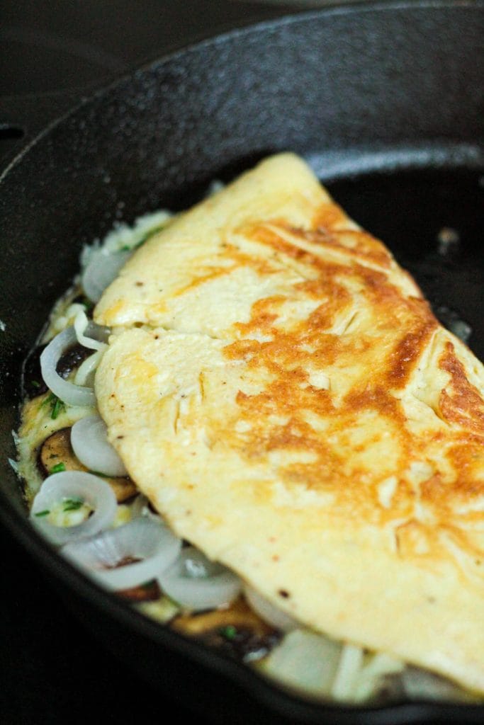 omelette with mushrooms in a cast iron pan