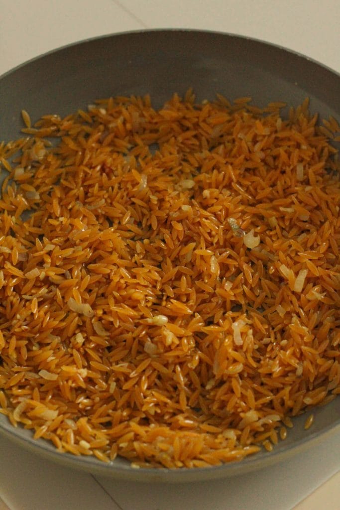 orzo with onions in a pan