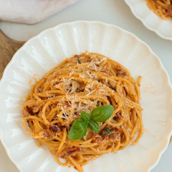 creamy sun-dried tomato pasta on a plate with basil