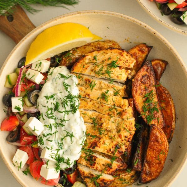 Greek-style lemon herb chicken breast with potatoes, tzatziki and Greek salad on the side