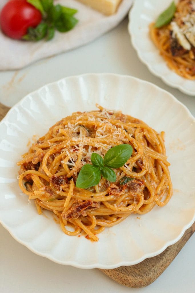 creamy sun-dried tomato pasta on a plate with basil