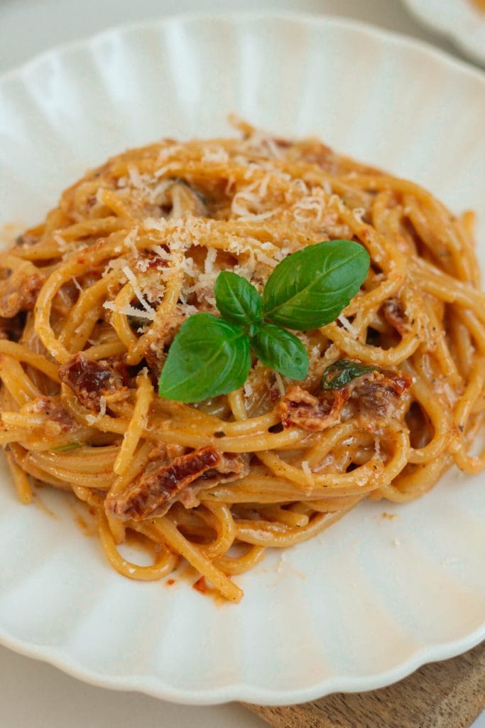 creamy sun-dried tomato pasta on a plate with basil