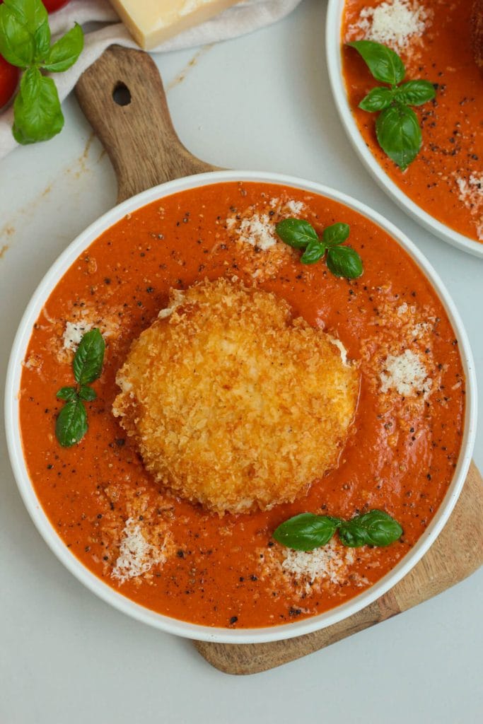 crispy fried burrata with tomato sauce and basil on a plate