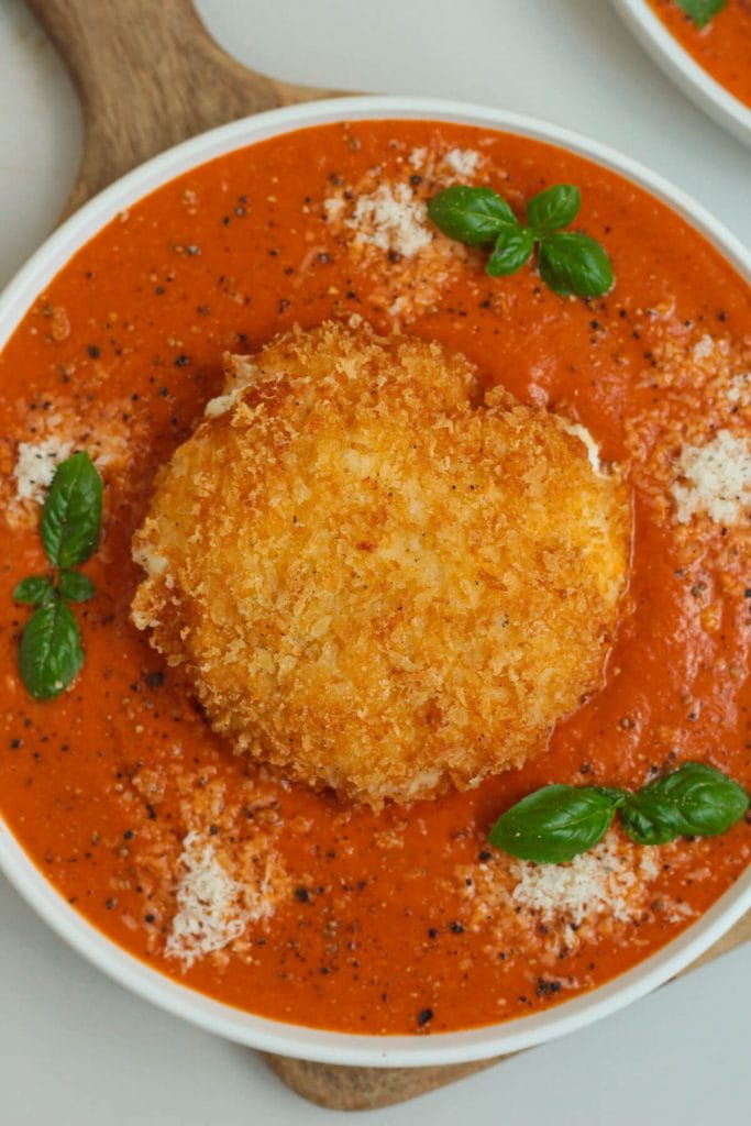 crispy fried burrata with tomato sauce and basil on a plate