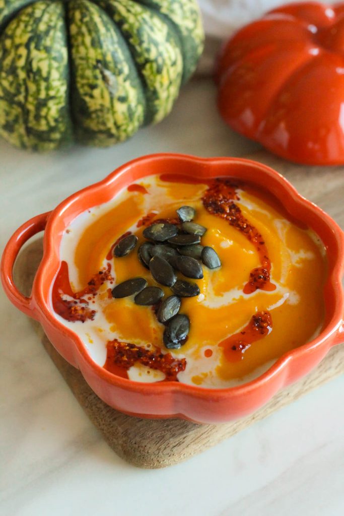 creamy roasted pumpkin soup topped with pumpkin seeds, chili oil and coconut milk