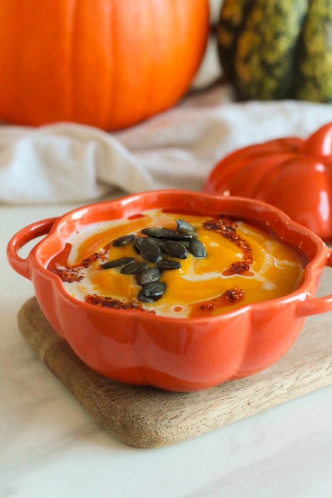 creamy roasted pumpkin soup topped with pumpkin seeds, chili oil and coconut milk